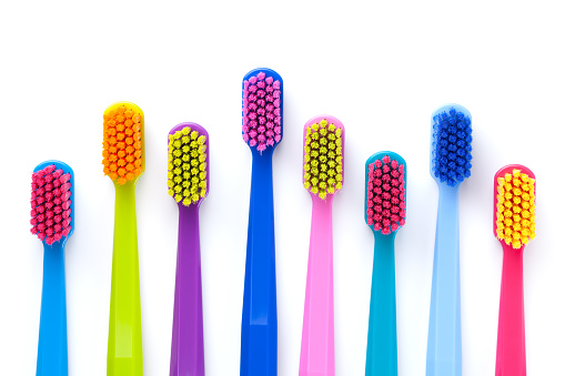 Set of multicolored toothbrushes isolated over white background. Flat lay. Top view