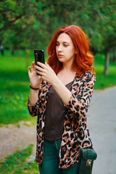 garota bonita olha para a rota no aplicativo do smartphone. - mobilestock freedom enjoyment blue - fotografias e filmes do acervo