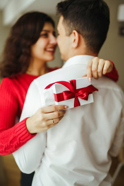 istock Happy couple with gift hugging. Valentines day celebration concept. Relationship, surprise and love concept. 1295505016