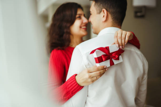 istock Happy couple with gift hugging. Valentines day celebration concept. Relationship, surprise and love concept. 1295505554