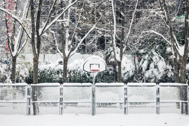 Front view of a street basketball court under the snow during the heavy Filomena storm in Madrid, Spain.