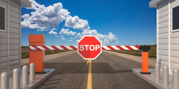 istock Closed barrier gate and stop sign, blue sky background. 3d illustration 1295508617