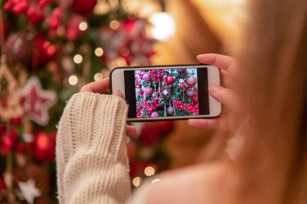 istock Woman photographing a Christmas tree 1295508720