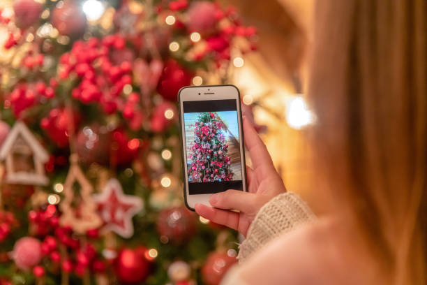 istock Woman photographing a Christmas tree 1295508755