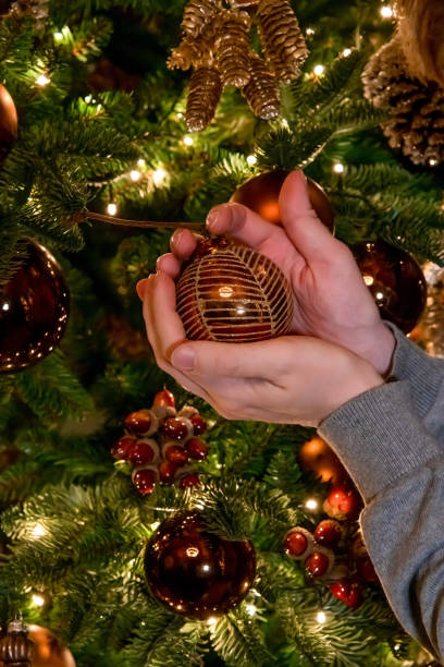 istock Man holds gold Christmas ornament 1295508906