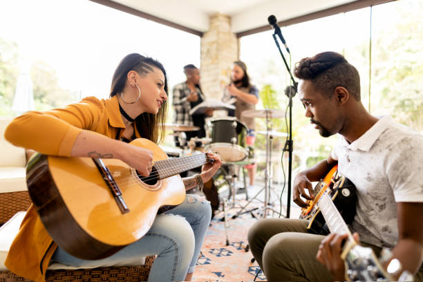 istock Two young friends playing guitar together during practice with their band 1295509587