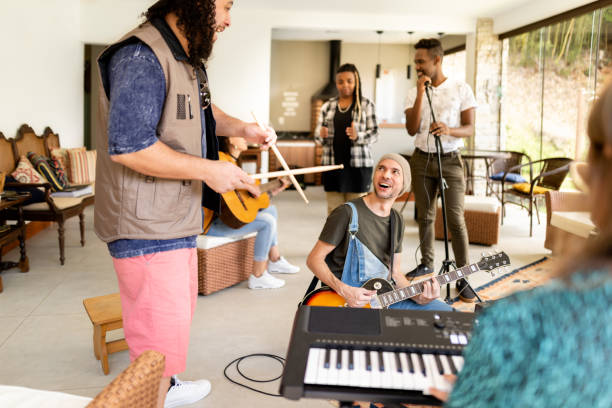 istock Smiling group of young musicians jamming together in a home studio 1295509603