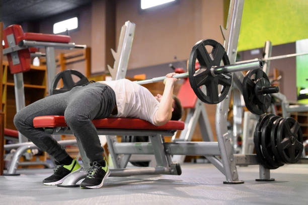 istock Young Man Doing Bench Press Workout In Gym. High quality photo 1295510771