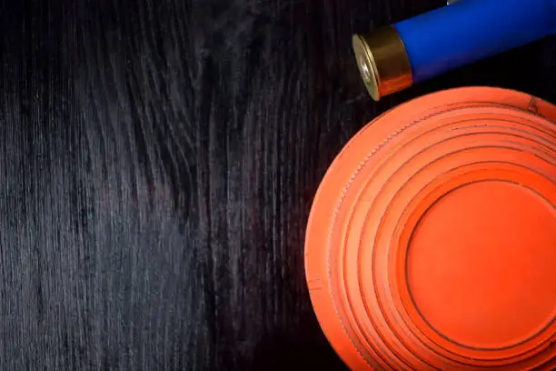 Photo of Clay target for skeet shooting and a bullet shell