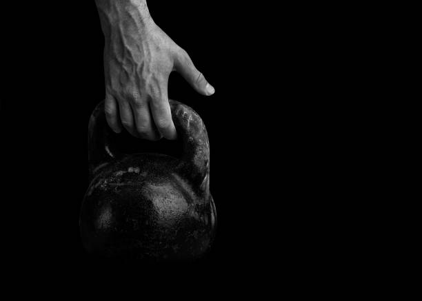 The athlete strong hand takes the kettlebell. Weight-lifting.