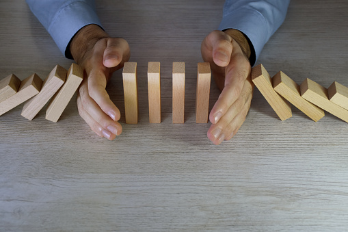 Businessman stop domino effect. Insurance concept and risk management