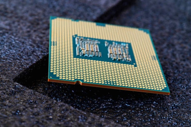 Pc micro CPU with gold plated contacts on a textured dark background. Modern central processing unit close-up. Desktop computer hardware components for assembly, upgrade and repair. Macro. Shallow DoF. Front view. micro cpu de pc con contactos chapados en oro sobre un fondo oscuro texturizado. moderno primer plano de la unidad central de procesamiento. componentes de hardware de computadoras de escritorio para montaje, actualización y reparación. macro. dof superf