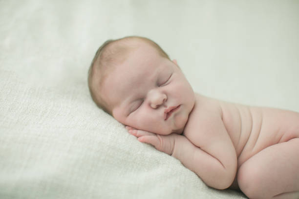 close up of a sweet newborn infant baby girl laying on a cream colored neutral background - 7585 imagens e fotografias de stock