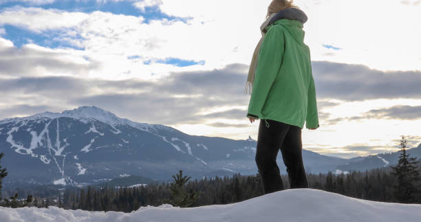 istock Mature woman hikes through snow, ski resort distant 1295520701