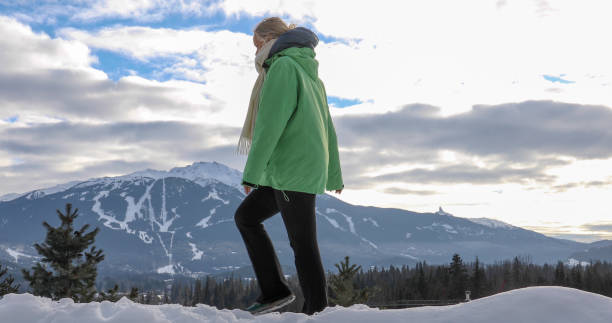 istock Mature woman hikes through snow, ski resort distant 1295520744