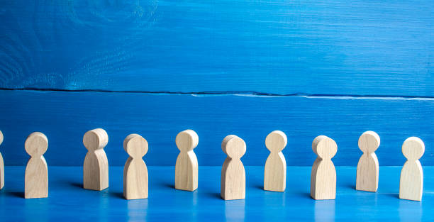 istock Figures of people on a blue background. Maintaining a safe distance in queue. New normal. Society concept. Communication. Population and citizens. Faceless persons. Detachment and loneliness 1295523520