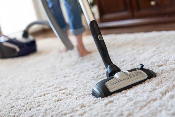 istock Woman using a vacuum cleaner while cleaning carpet in the house. 1295524403