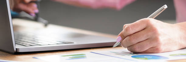istock Table at home laptop and documents, female hands 1295524652