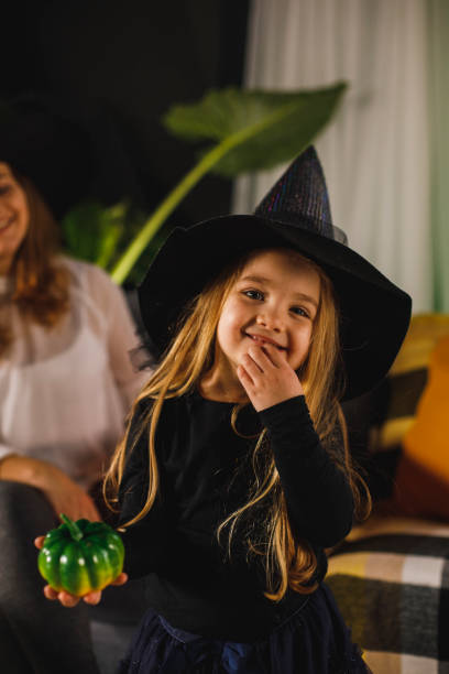istock Smiling girl in witch's costume looking at camera 1295525336