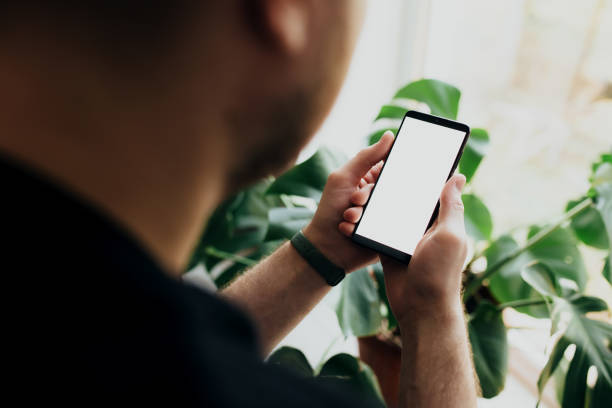 istock Man is holding smartphone with white screen 1295527288