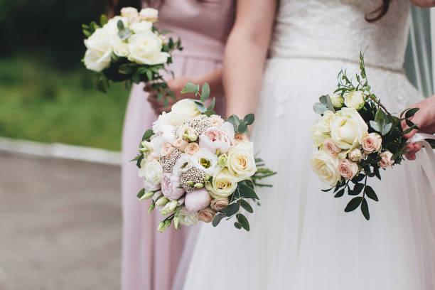 istock Bride in white dress is holding wedding bouquet with bridesmaids 1295527607