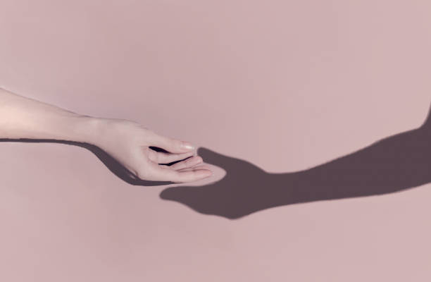 istock Romantic concept. A woman's hand reaches out towards the shadow of a man's hand which pulls towards. An analogy of meeting with a virtual partner on the network. 1295539899
