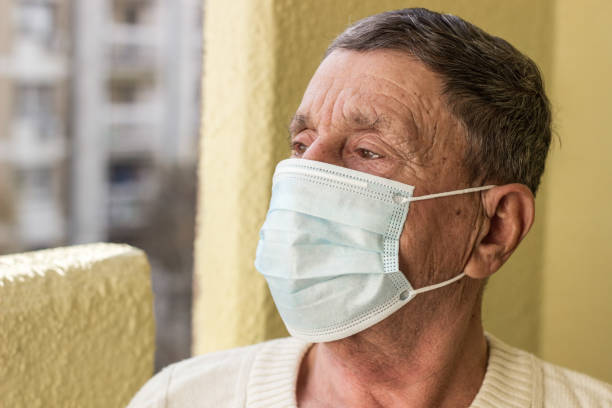 istock Senior man wearing medical facemask 1295540309