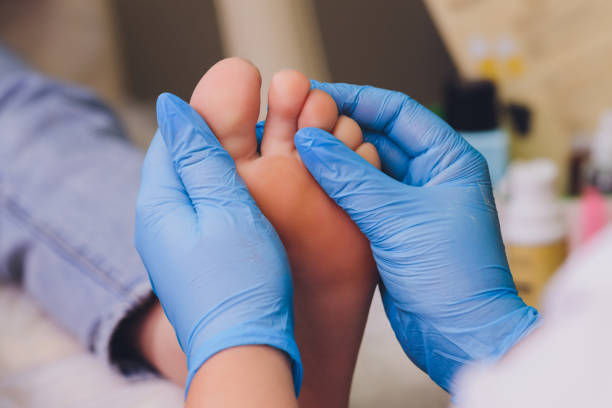 istock Therapist hands in protective gloves massaging woman's feet. 1295540532