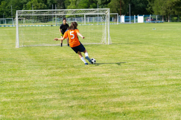 istock Female soccer player practices shots on goal on a turf field 1295541601