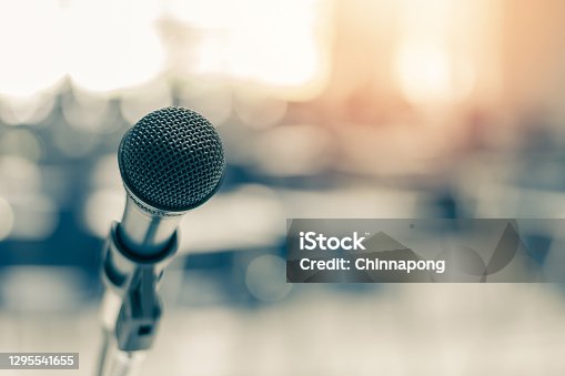 istock Microphone voice speaker in business seminar, speech presentation, town hall meeting, lecture hall or conference room in corporate or community event for host or townhall public hearing 1295541655