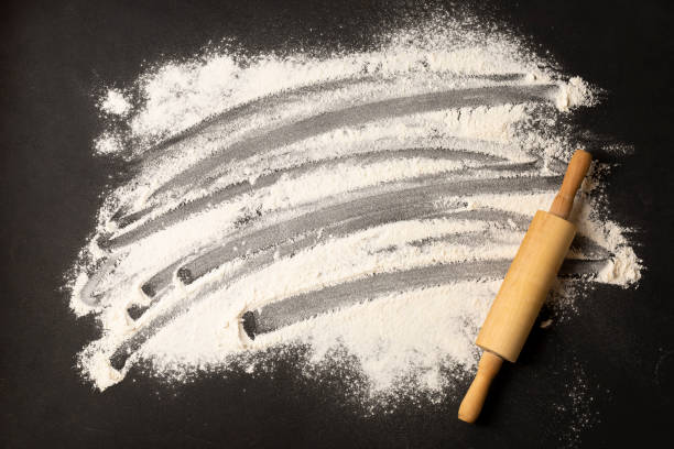 istock Rolling Pin with Flour on black background. Baking Ingredients Concept 1295542328