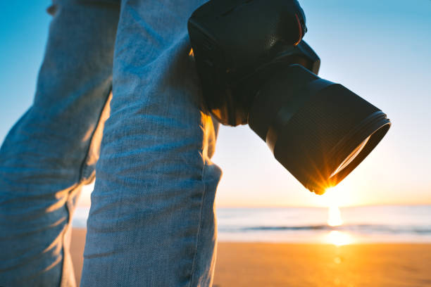 istock Photographer with his camera on the beach at sunset 1295545086
