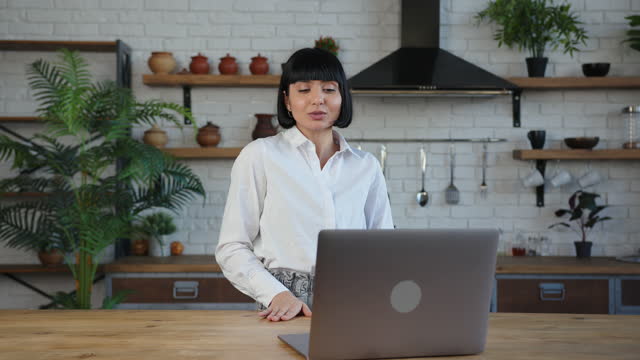 Young lady with elegant haircut has videocall on laptop