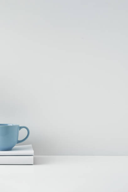 istock The mug stands on a stack of books on a white background. Natural and eco-friendly materials. Copy space, mock up. 1295546804