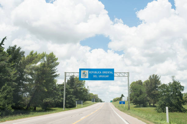 straßenlandschaft mit dem eingangsschild zur orientalischen republik uruguay, an der landgrenze dieses landes mit argentinien - oriental republic of uraguay stock-fotos und bilder