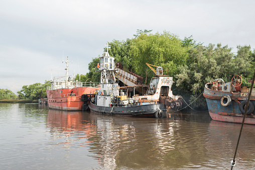 Carmelo, Colonia / Uruguay; Dec 27, 2018: tugboat accommodating a ship that had previously collided, along with two others, against the swing bridge