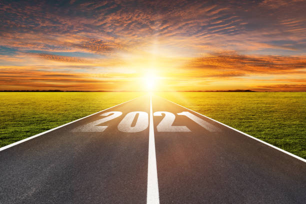 istock Empty asphalt street road and writing text 2021 on roadway. 1295560285
