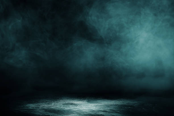 istock Studio dark room concrete floor grunge texture background with spot lighting and fog or mist in black background. 1295560340