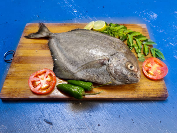 istock Closeup view of Fresh Black Pomfret Fish decorated with herbs and vegetables,Selective focus. 1295561069