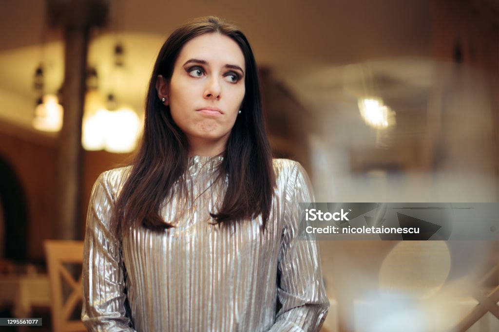 Bored Woman at a Party Thinking of Something Else Unhappy girlfriend attending a boring event on holidays Embarrassment Stock Photo