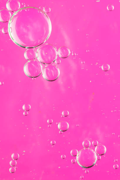 istock oil drops on water on a pink background 1295561821