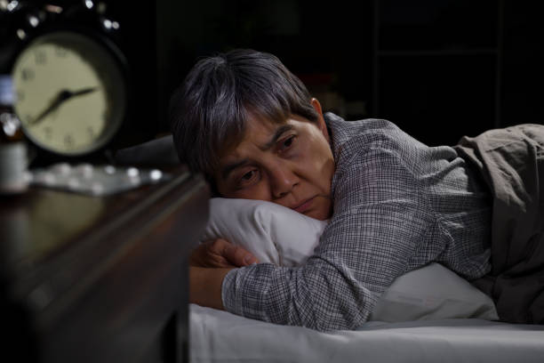 istock Depressed senior woman lying in bed cannot sleep from insomnia 1295561982