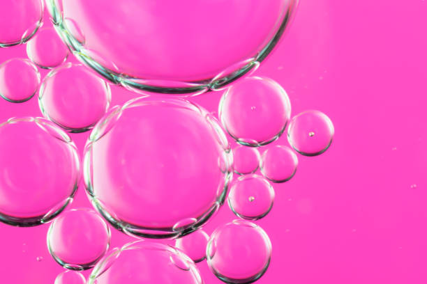 istock oil drops on water on a pink background 1295562720