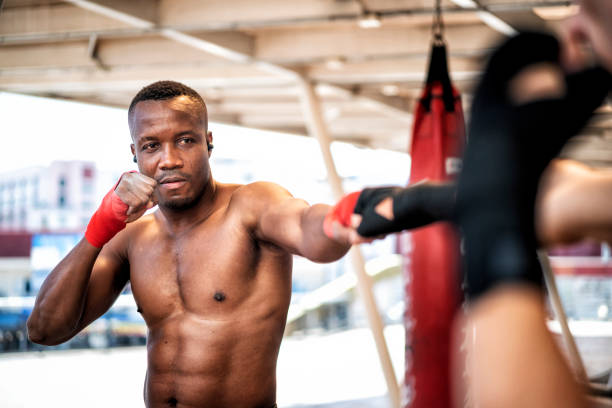 American boxer and his coach doing some sparring at gym