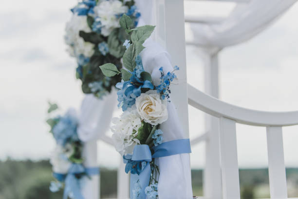 istock White roses and Hydrangeas with blue ribbon decore on white wedding arch 1295569175