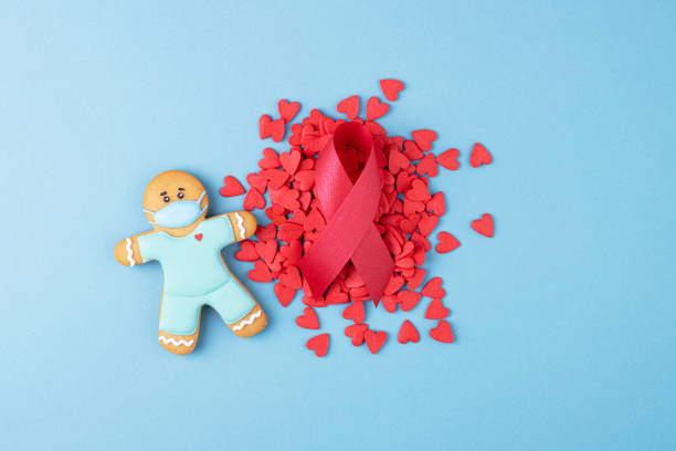 red ribbon and gingerbread man, small red hearts, the day of struggle against aids - aids awareness ribbon imagens e fotografias de stock