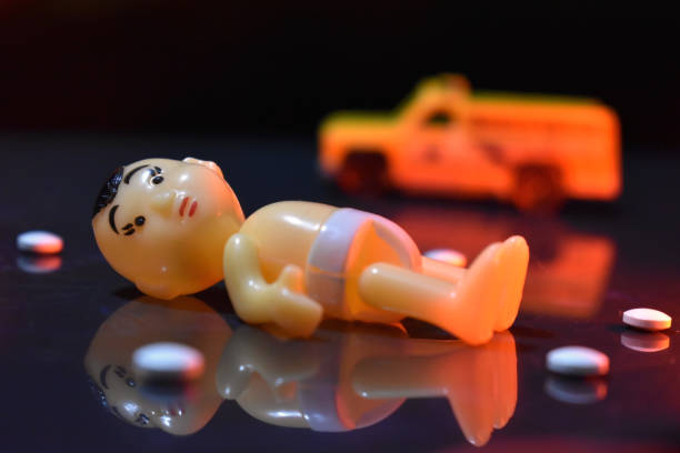istock Baby model lying on ground with ambulance in background. 1295570686