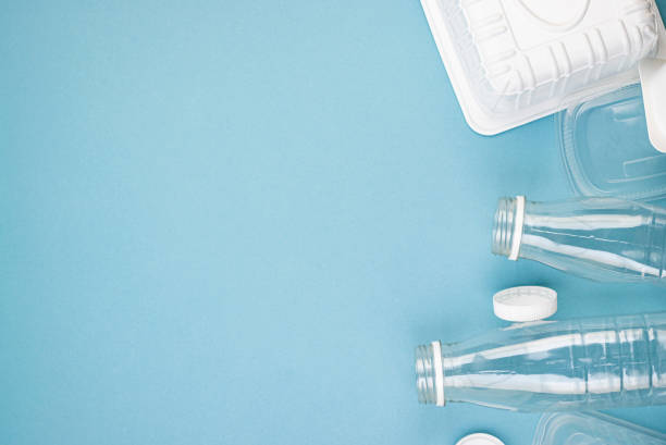 istock Empty plastic bottles with white lids, packages and dishes in a pile on a blue background 1295571541