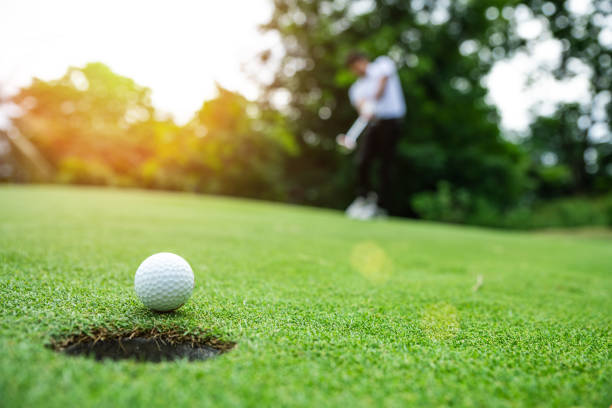 golfball auf grünem rasen - golf power golf course challenge stock-fotos und bilder