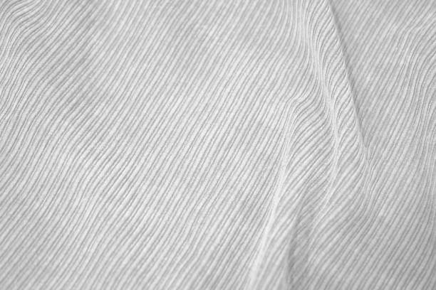 White abstract fabric background. Durable fabric texture background. Ribbed fabric with soft pleats. White elegant background.